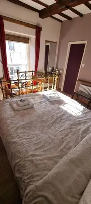 a large white bed in a room with chairs at The Kilverts Inn in Hay-on-Wye