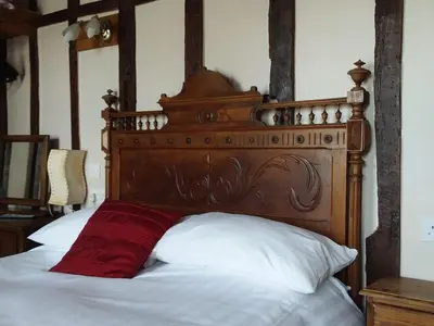 a bed with a wooden headboard and a red pillow at The Kilverts Inn in Hay-on-Wye