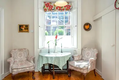 a room with two chairs and a table with a vase on it at Colomendy in Montgomery