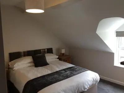 a bedroom with a bed and a window at Swyn y Mor beach close Pet friendly hot tub in Barmouth