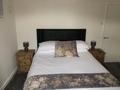 a bedroom with a large bed with a pillow on it at Swyn y Mor beach close Pet friendly hot tub in Barmouth