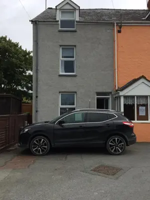 a black car parked in front of a house at Swyn y Mor beach close Pet friendly hot tub in Barmouth