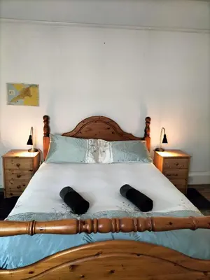 a bedroom with a wooden bed with two night stands at Bryn Awel in Aberystwyth