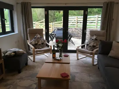 a living room with a couch and chairs and a table at Ty Glo Cottage in Brecon