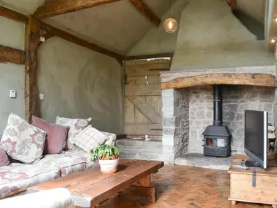 a living room with a couch and a fireplace at The Cart Shed in Kings Pyon