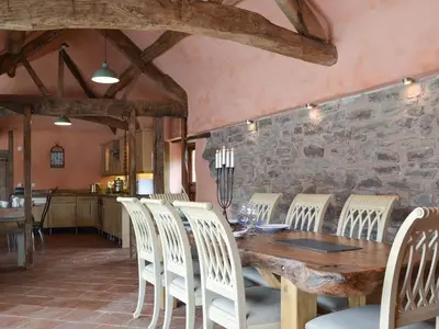 a dining room with a wooden table and white chairs at The Cart Shed in Kings Pyon