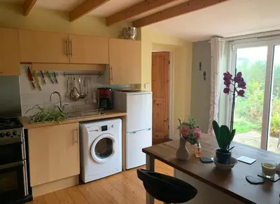 a kitchen with a washer and dryer in it at The Granary Country Retreat in Lampeter