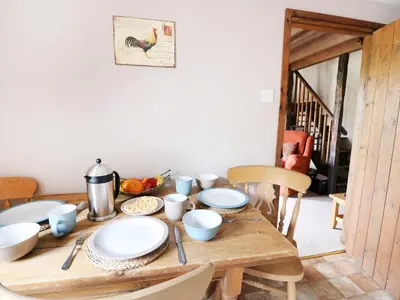 a wooden table with plates and bowls on it at Beech Cottage in Llanidloes