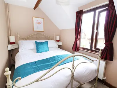 a bedroom with a bed and a window at Beech Cottage in Llanidloes