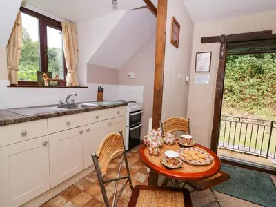a kitchen with a table and chairs and a sink at Oak Cottage in Llanidloes