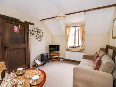 a living room with a couch and a table at Oak Cottage in Llanidloes