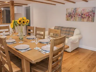 a dining room with a wooden table and chairs at The Cow Byre, Heath Farm in Clee Saint Margaret