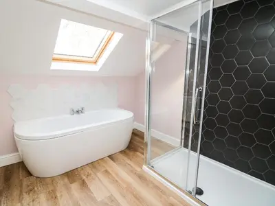 a bathroom with a white tub and a shower at Water Street in Aberaeron