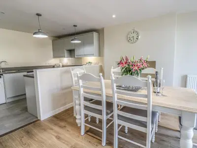 a kitchen and dining room with a wooden table and chairs at Y Cilgwyn in Blaenau-Ffestiniog
