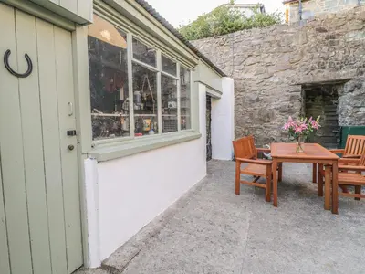 a patio with a table and chairs next to a building at Y Cilgwyn in Blaenau-Ffestiniog