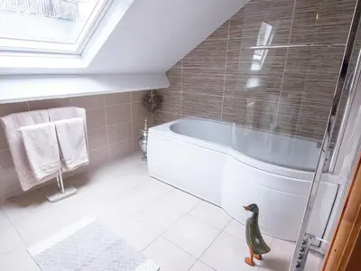 a bathroom with a tub and a duck toy in the floor at Cefn Uchaf Cottage in Llanbedr