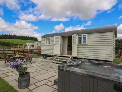 a tiny house on a patio with a hot tub at Hillside View in Saint Harmon