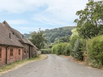 an empty road next to an old brick building at Old Hall Barn 1 in Church Stretton