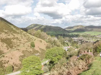a view of a town on a hill with mountains at Old Hall Barn 1 in Church Stretton