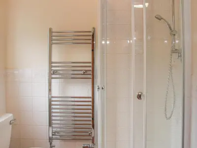 a bathroom with a shower and a toilet and a sink at Waggoners Cottage in Montgomery
