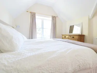 a white bed in a room with a window at School House in Builth Wells