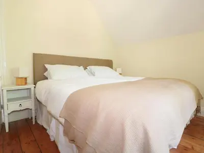 a bedroom with a white bed and a night stand at School House in Builth Wells