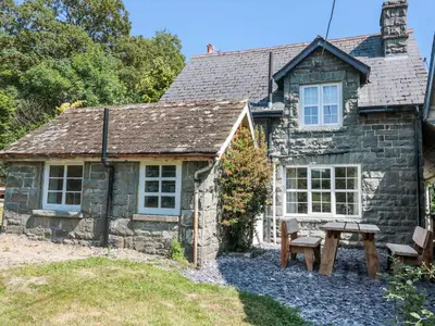a stone house with a picnic table in front of it at School House in Builth Wells