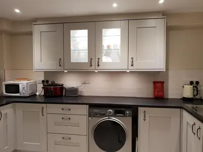 a kitchen with white cabinets and a washing machine at 138a Old Star & Garter in Ludlow