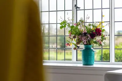 a blue vase filled with flowers sitting on a window sill at The Hall in Bucknell