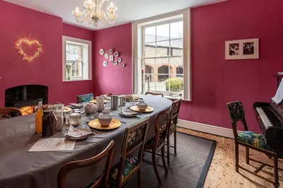 a dining room with a long table and purple walls at The Hall in Bucknell