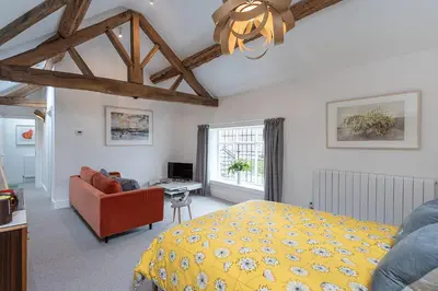 a bedroom with a yellow bed and a chair at The Hall in Bucknell