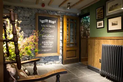a entrance to a restaurant with a sign on the wall at Victoria Inn in Llanbedr