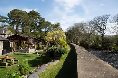 a path next to a river next to a house at Victoria Inn in Llanbedr
