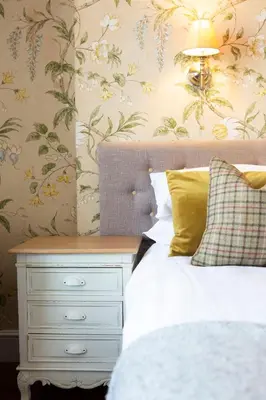 a bedroom with a bed and a nightstand with a white bed sidx sidx sidx at Victoria Inn in Llanbedr
