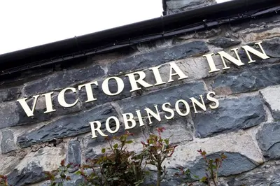 a sign on the side of a brick building at Victoria Inn in Llanbedr