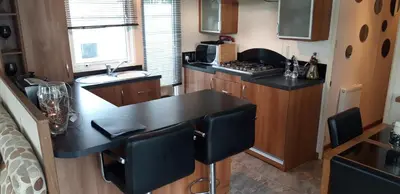 a kitchen with a black counter top in a caravan at Dyfed 23 in Borth