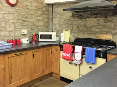 a kitchen with a stove and a microwave at Llwyn Llwyd Cottage in Brecon