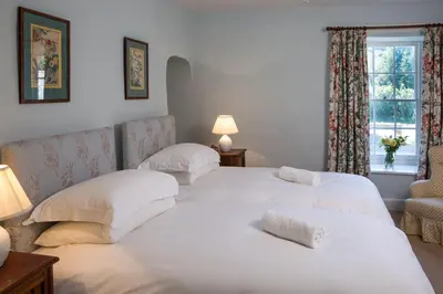 two white beds in a room with a window at The Old House, Llwyn Madoc in Llanwrtyd Wells