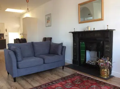 a living room with a blue couch and a fireplace at 2 Yr Hen Fanc in Aberaeron