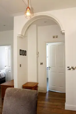 an archway in a living room with a door at 2 Yr Hen Fanc in Aberaeron