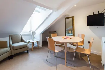 a dining room with a table and chairs and a television at No 47 Marine Terrace in Aberystwyth
