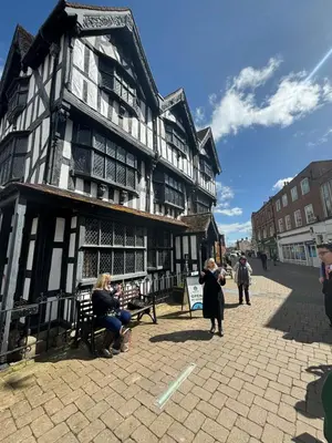 a large black and white building with people sitting outside at The Hayloft, Wall End Farm in Leominster
