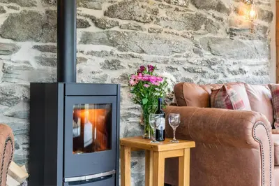 a fireplace in a living room with a couch and flowers at 3 Bed in Bala oc-bow69 in Bala