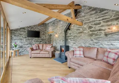a living room with two couches and a stone wall at 3 Bed in Bala oc-bow69 in Bala