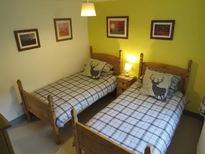 two beds in a room with green walls at Yr Hen Farcdy in Talsarnau