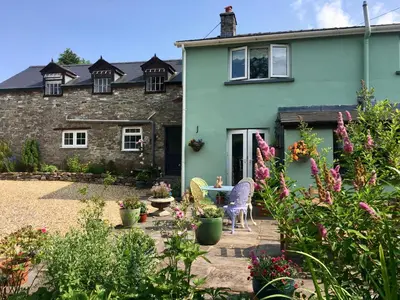 a garden in front of a house with flowers at Brecon Boutique Breaks Wild Land in Sennybridge
