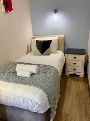 a bedroom with a bed with two towels on it at The Workshop in Aberystwyth
