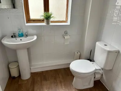 a white bathroom with a toilet and a sink at The Workshop in Aberystwyth