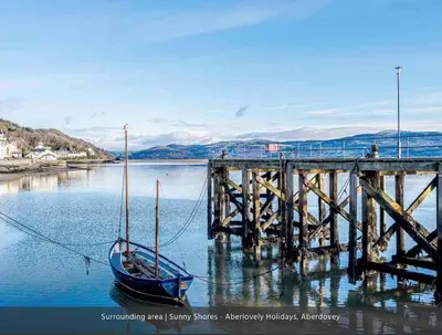 a boat tied to a dock next to a pier at Westhaven One in Aberdyfi