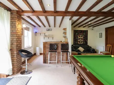 a living room with a pool table and a bar at Pengwern in Pennant-Melangell